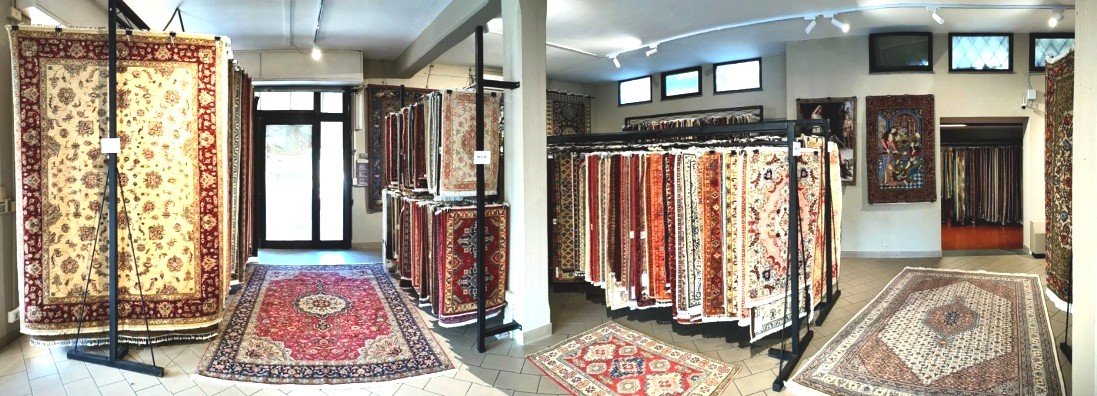 sala espositiva con tappeti in varie dimensioni appesi su espositori sfogliabili